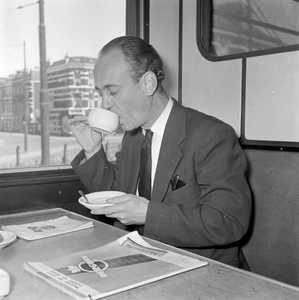 152220 Afbeelding van journalist Henk Hermans die demonstreert hoe je een kop koffie drinkt in een trein.Zie ook Tussen ...
